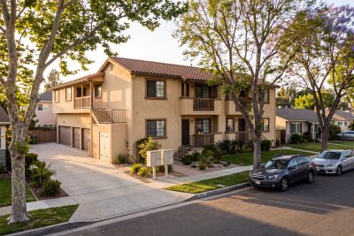 Two-story stucco fourplex rental on a tree-lined residential street in Tustin, Orange County